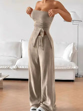 Beige ribbed knit jumpsuit with ruched bodice and side ties