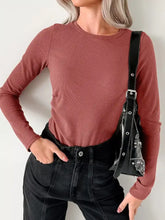 A ribbed long sleeve fitted dusty rose bodysuit with a round neckline in soft stretch fabric