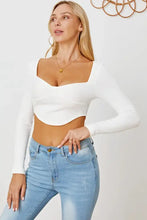 Woman in ribbed long sleeve crop top and light-wash jeans