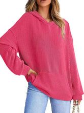 A vibrant pink ribbed oversized hoodie with long sleeves and a slightly stretchy fit featuring a front pocket