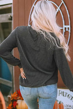 Woman in ribbed round neck long sleeve graphic sweatshirt and jeans