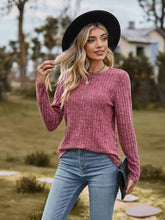 Maroon ribbed round neck long sleeve tunic sweater with black hat and blue jeans