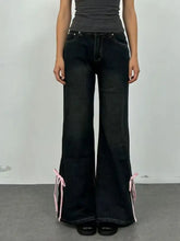 Black classic denim flare jeans with pink ribbon ties at the cuffs for a perfect fit and stylish detail