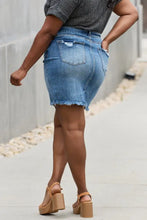A back view of risen amelia full size denim mini skirt featuring distressed back pocket and frayed hem details