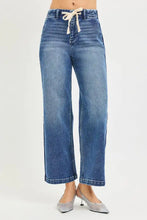 High-waisted risen jeans in blue denim with a cream drawstring tie and wide-leg jeans style featuring a crotch seam
