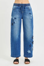 Blue denim cropped barrel pants with risen elastic band and star patch appliqués along the sides