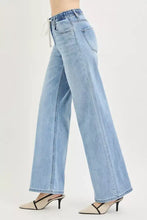 Risen light-wash denim slouchy wide jeans with elastic waistband and white drawstring for comfortable wear