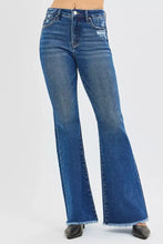 Blue denim risen high rise flare jeans with frayed hems and a distressed patch on the thigh in cotton blend