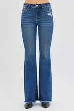 Blue denim risen high rise flare jeans with distressed details and frayed hems in a high rise flare style