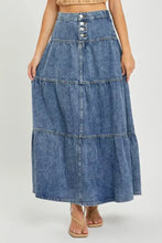 A mid-wash blue denim risen high rise ruffle maxi skirt with tiered a-line silhouette and button closure at waist