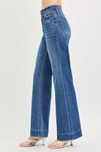 Mid-wash blue denim risen high rise wide leg jeans with classic five-pocket design and rolled cuffs