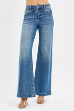 Risen high rise wide leg blue denim jeans with front yoke and heart back pocket in a flared cut design