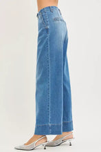 Light-wash blue denim risen slouchy wide leg jeans with high waist, pleats, and rolled cuffs for casual wear