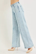 Light-wash denim risen slouchy wide leg jeans with high-rise waist and visible stitching along the seams