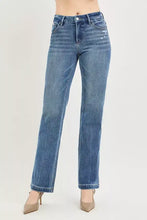 Medium-wash blue denim jeans with a high-rise fit and crease line offering a polished aesthetic at the natural waistline