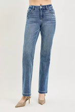 High-waisted straight-leg denim jeans in medium blue wash with crease line and polished aesthetic at the natural waistline