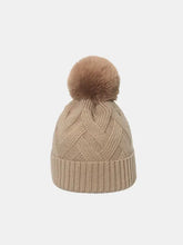 Beige roll rim hat with faux fur pom-pom and chevron knit pattern