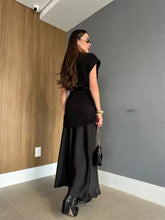 Black satin maxi skirt with ribbed top and gold chain handbag