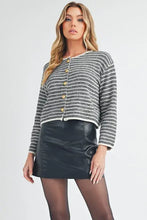 Round neck cardigan with gold buttons and black leather skirt