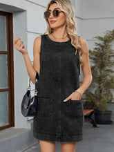 Black denim sleeveless round neck denim overall dress with front zipper and two patch pockets
