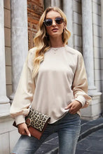 Woman in round neck dropped shoulder sweatshirt with jeans and clutch