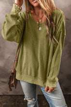 Woman in round neck dropped shoulder sweatshirt, jeans, and bag