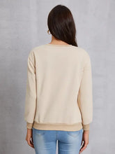 Beige round neck dropped shoulder sweatshirt over light wash jeans