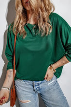 Woman in round neck long sleeve t-shirt with distressed light-wash jeans