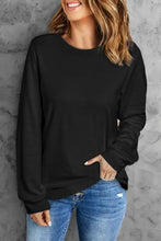Black round neck long sleeve top with ribbed cuffs and hem