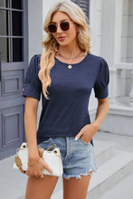 Woman in round neck puff sleeve top and denim shorts with handbag