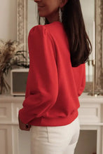 Woman in red puff-sleeve round neck short sleeve sweatshirt and white jeans