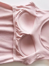 A soft pink round neck tank with smooth fabric and built-in bra designed for comfortable everyday wear