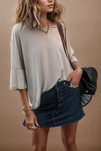 Woman in round neck three-quarter sleeve t-shirt with denim mini skirt