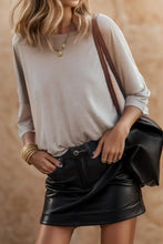 Light gray round neck three-quarter sleeve top with black leather mini skirt