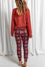 Red and black plaid drawstring lounge pants with a snug fit paired with a round neck top featuring long sleeve length
