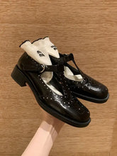 Round toe block heels loafers in black patent leather with brogue detailing