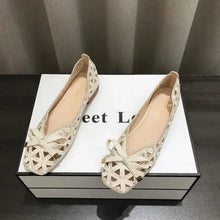 Pair of beige cut-out round toe flats with bows