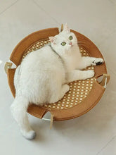 Round elevated woven pet bed with sturdy wood frame in cozy light brown tones