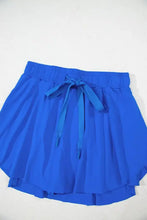 Royal blue pleated shorts with drawstring waistband and teal ribbon tie