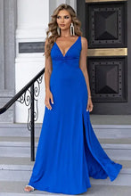 Woman in royal blue twisted slit plunge maxi dress with thigh-high slit