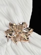 Gold-toned metallic flower-shaped belt buckle with detailed petals on the back of a ruched halter neck cami