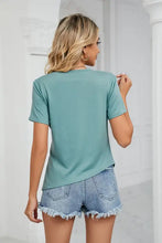 Woman modeling teal regular sleeve ruched hem crewneck t-shirt with frayed denim shorts