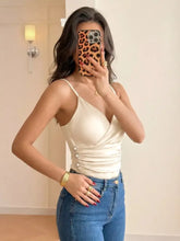 Cream-colored satin spaghetti strap bodysuit with thin straps and front button detailing in a ruched design