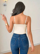 Cream-colored satin ruched spaghetti strap bodysuit with thin straps and silver button detailing on the back side