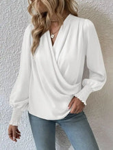 White satin ruched surplice blouse with long sleeves and draped v-neckline for elegant wear
