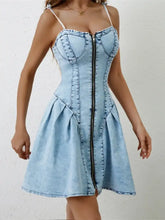 Light blue denim dress with ruched zip front and spaghetti straps featuring a corset-style fit