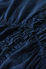 Dark blue ruffle hem tie neck blouse featuring gathered stitching and ruffled fabric detail along the edge