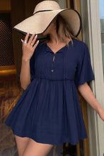 Navy blue short-sleeved dress with v-neck and button closure featuring a ruffle hem and tie neck detail