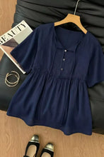 Navy blue short-sleeved blouse with v-neck button-front and gathered waist in ruffle hem tie neck style