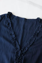 Navy blue ruffle hem tie neck blouse featuring a v neckline and delicate ruffled trim along the edges